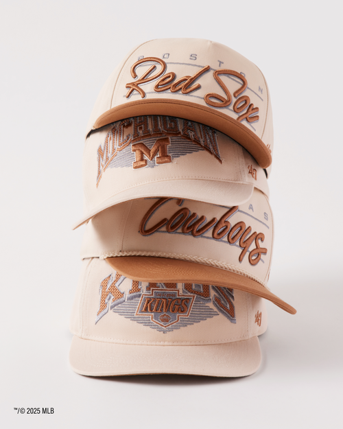 Beige cap with embroidered text and logos on a white background