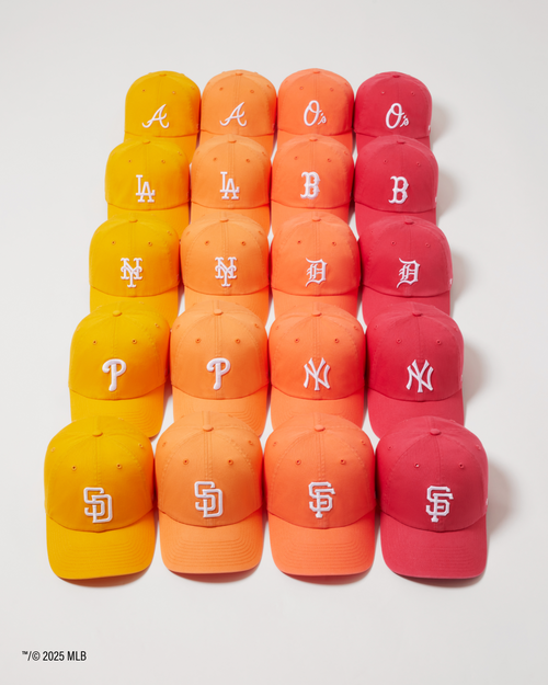 Stack of baseball caps with various team logos on a white background.