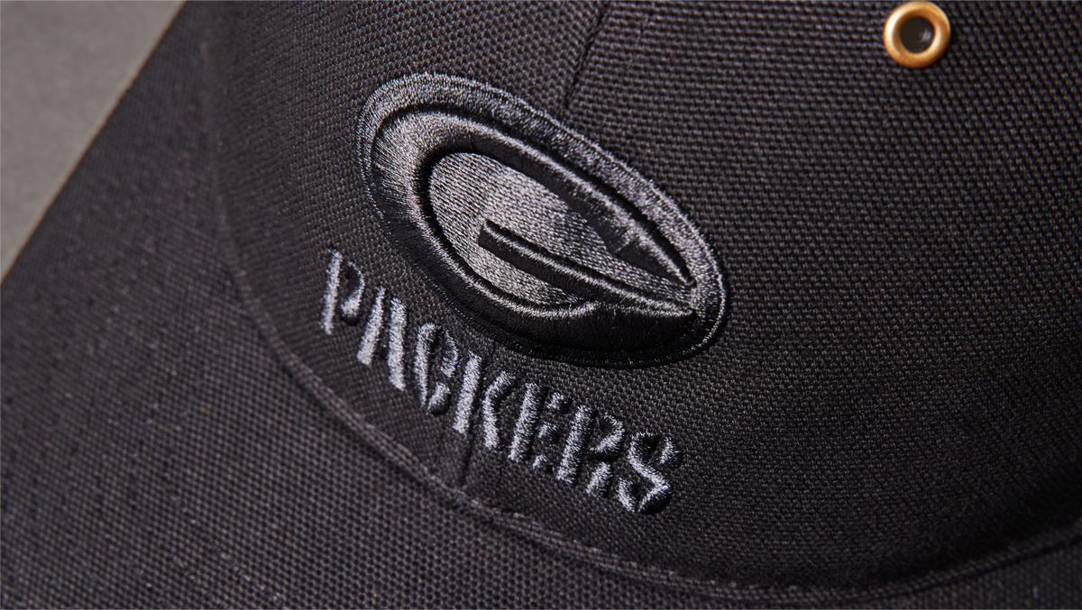 Black cap with 'Packers' logo on a dark background