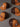 Brown and orange baseball caps with various logos on a gray background
