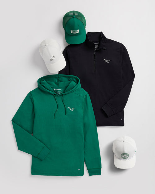 Green hoodie, black polo shirt, and white caps on a light gray background