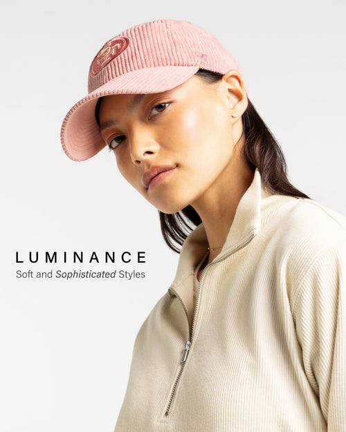 Person wearing a pink cap and beige jacket with 'Luminance' branding.