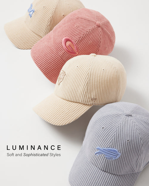 Four corduroy baseball caps in beige, pink, and gray with embroidered designs on a light background.
