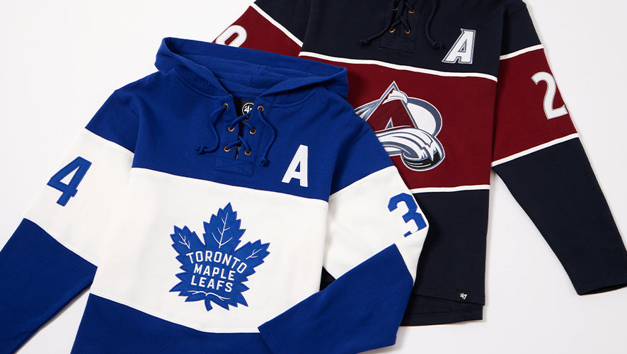 Toronto Maple Leafs and Colorado Avalanche lace-up NHL hoodies laid flat, showcasing retro team designs.