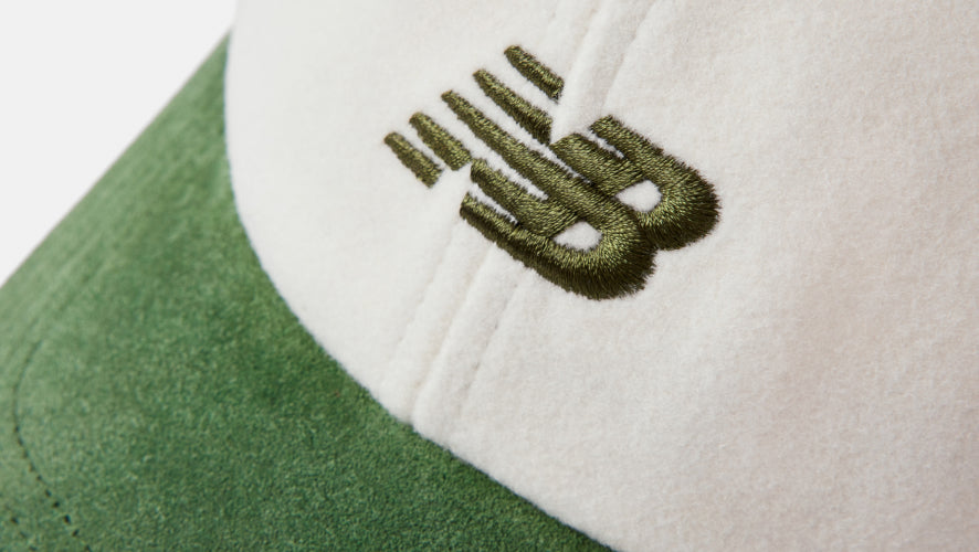 Close-up of a green and white cap with an embroidered logo on a white background