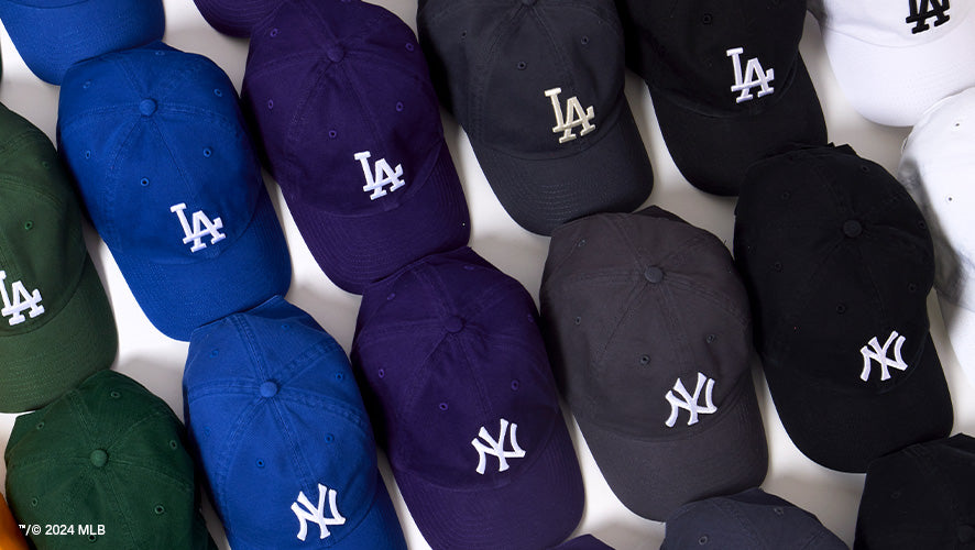 Top-down view of assorted LA Dodgers and NY Yankees Clean Up hats arranged in rows, showing a mix of classic and vibrant colors.