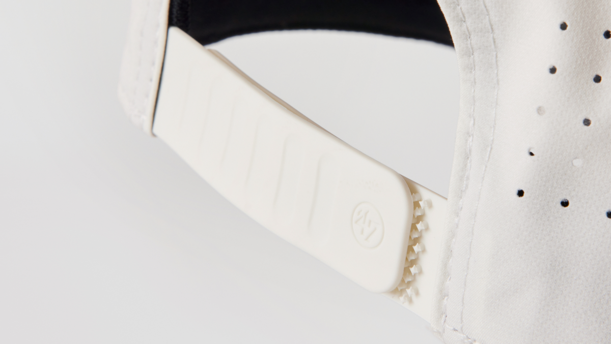 Snapback detailing on the back of white hat.