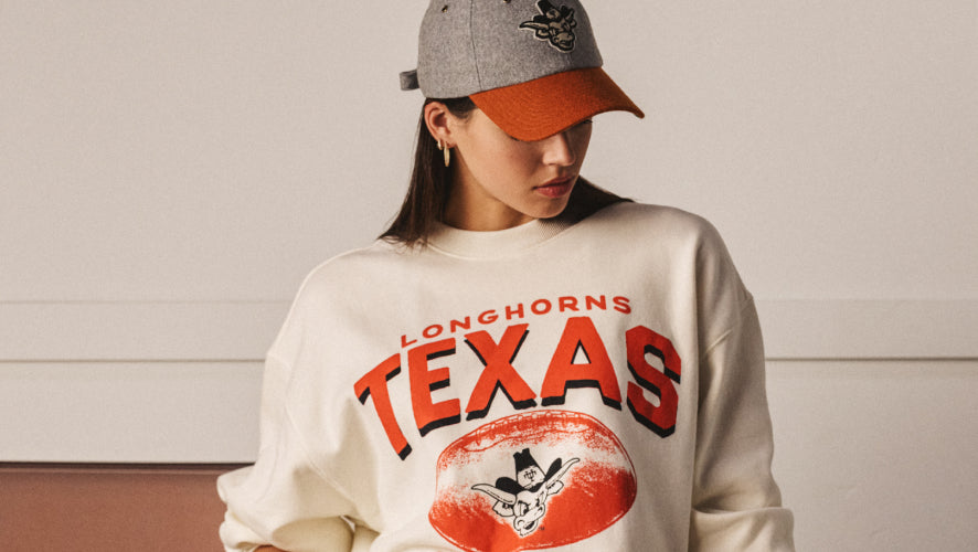 Person wearing a 'Longhorns Texas' sweatshirt with a cap.