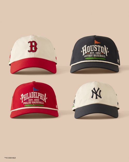 Four baseball caps from different teams on a beige background