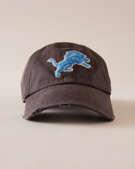 BROWN CAP WITH BLUE LOGO ON A BEIGE BACKGROUND