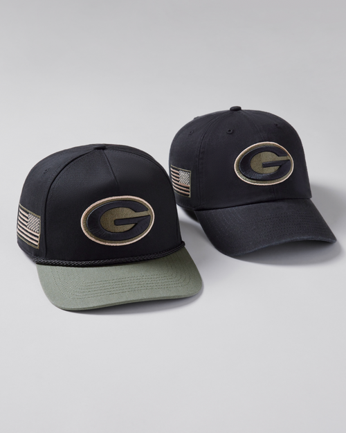 Two black and green baseball caps with logos on a light gray background