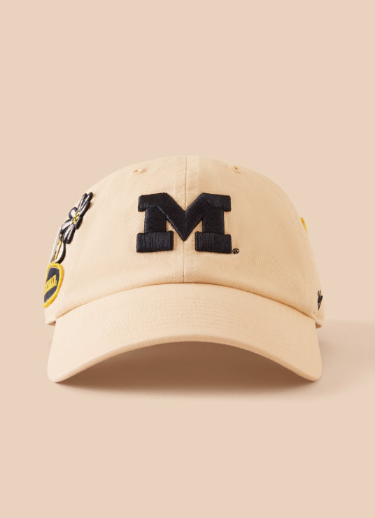 Beige cap with black 'M' logo on a beige background