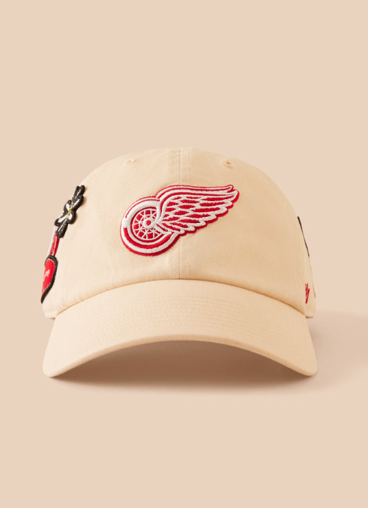 Beige cap with a red and white logo on a beige background