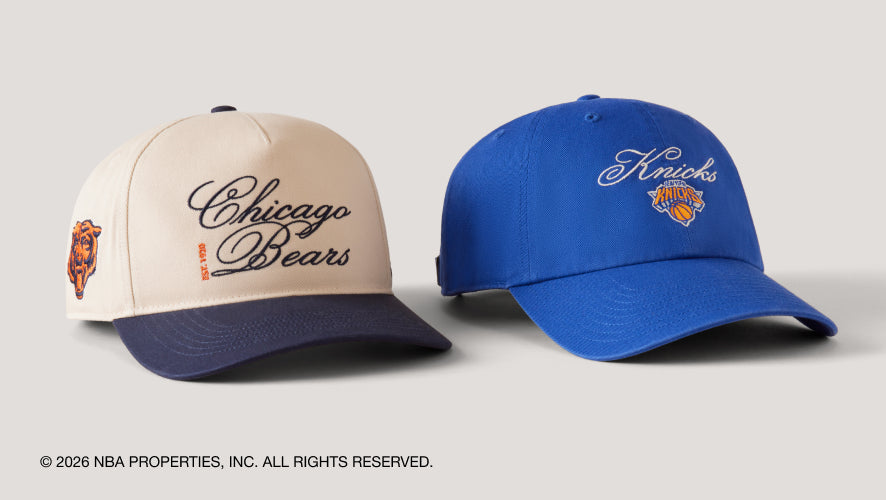 Two baseball caps, one beige with 'Chicago Bears' text and the other blue with 'Knicks' text, on a light gray background.
