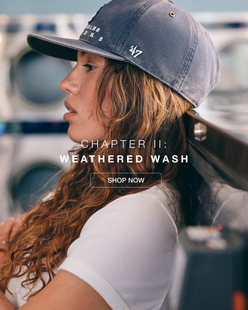 Person wearing a blue cap with '247' logo, sitting by a washing machine with text overlay 'Chapter II: Weathered Wash'.
