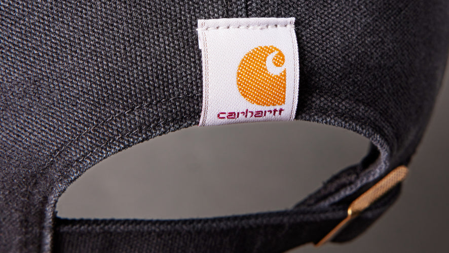 Close-up of a Carhartt logo on a cap's label.