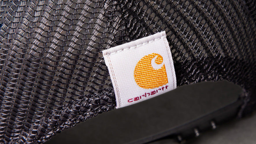Close-up of a Carhartt logo tag on a textured fabric background