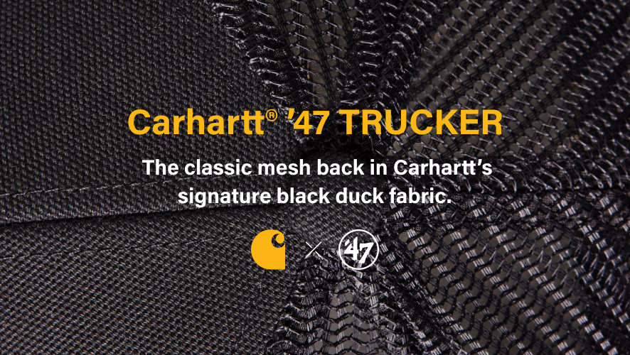 Close-up of Carhartt 47 Trucker cap with brand logos on black duck fabric. carhartt trucker- the classic mesh back in carhartts signature black duck fabric