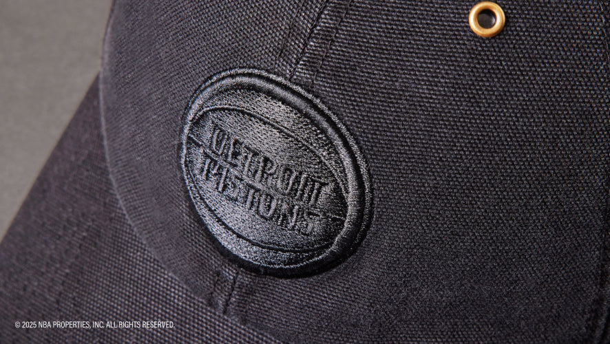 Close-up of a black cap with a logo on a dark background