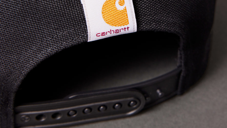 Black cap with Carhartt logo on a dark background