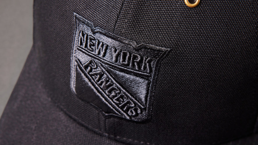 Black cap with New York Rangers logo on a gray background
