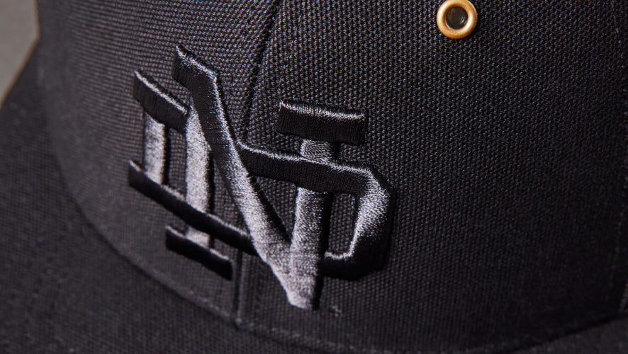 Black cap with a logo on a dark background