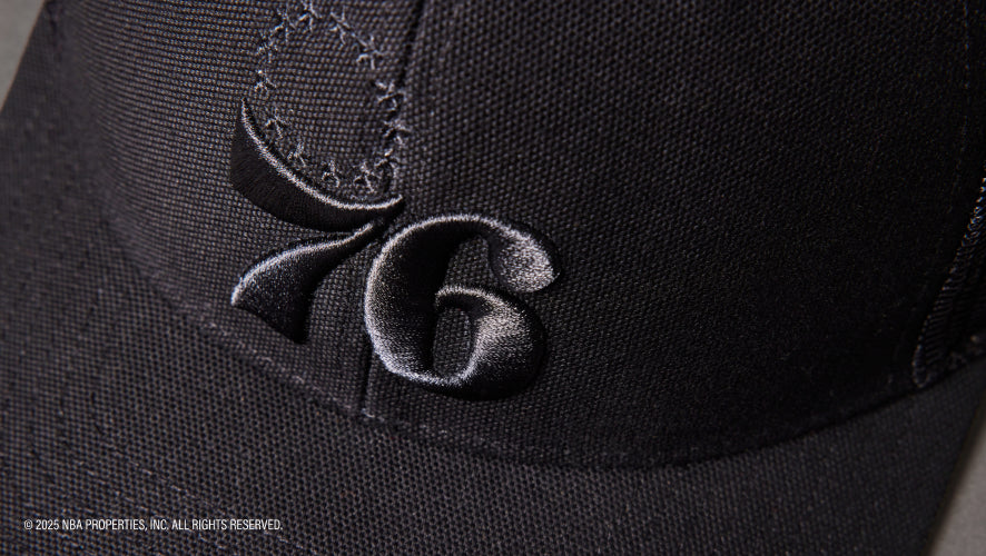 Black cap with embroidered logo on a dark background