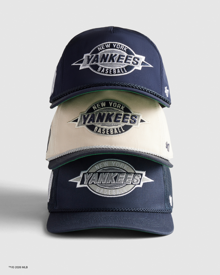THREE NEW YORK YANKEES BASEBALL CAPS STACKED ON A LIGHT GRAY BACKGROUND