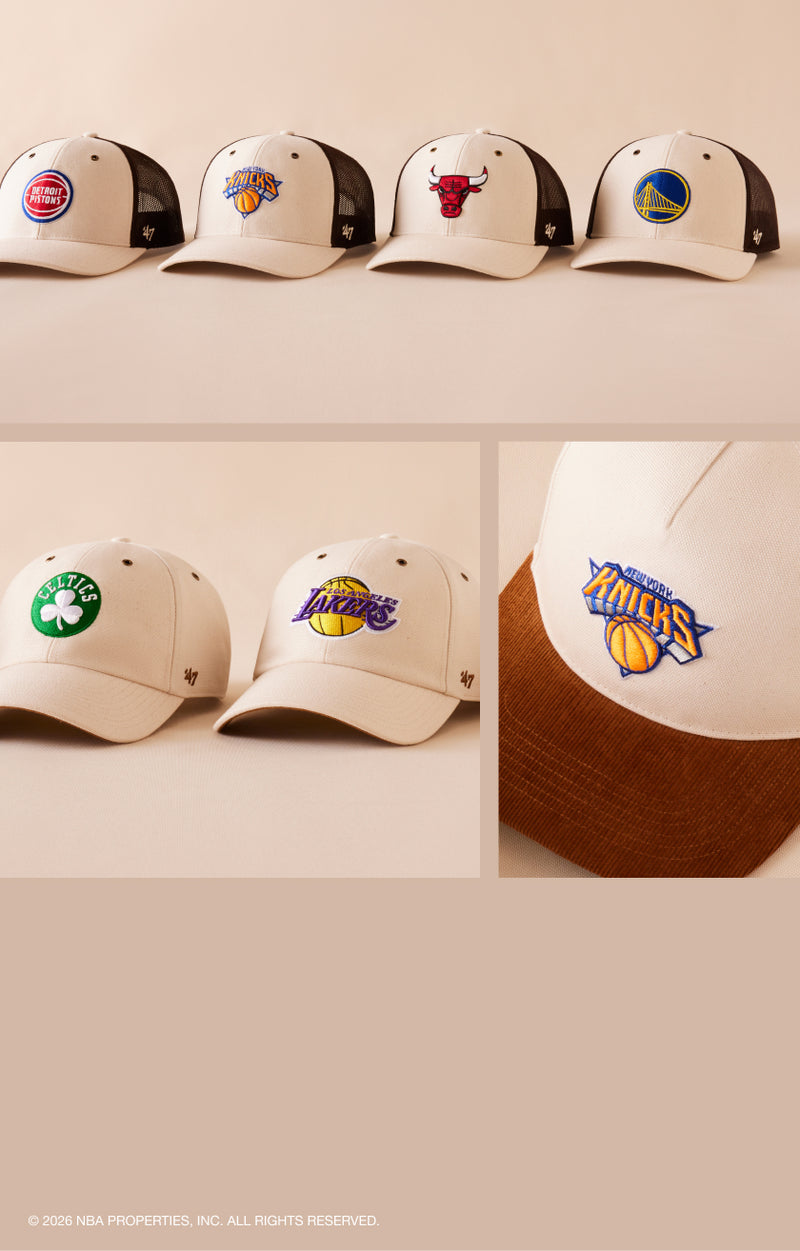 Collection of sports team logo caps on a white shelf.