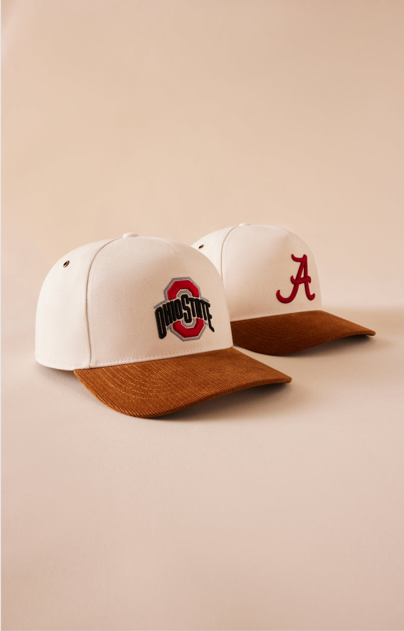 Two caps with Ohio State and Alabama logos on a beige background