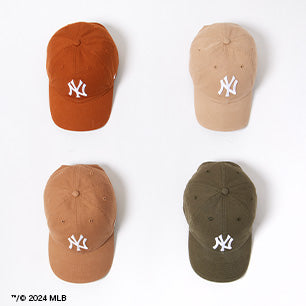 Overhead view of four New York Yankees caps in fall tones—burnt orange, tan, brown, and olive
