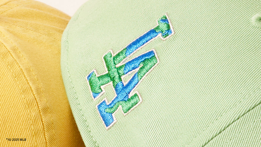 Detail image of The Los Angeles Dodgers logo on the back of a green hat in green and blue embroidery.