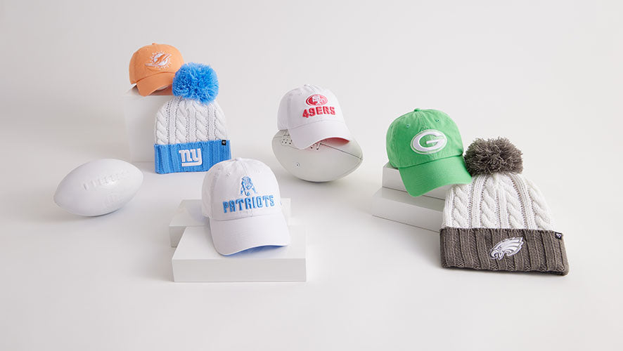 Assorted NFL knit hats and baseball caps featuring team logos for the Giants, Dolphins, 49ers, Patriots, Packers, and Eagles displayed on a white background.