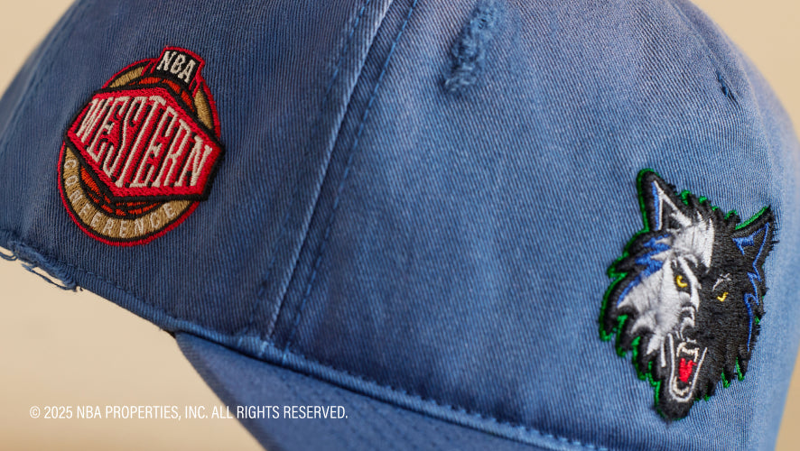 Blue denim cap with embroidered logo and text on a beige background