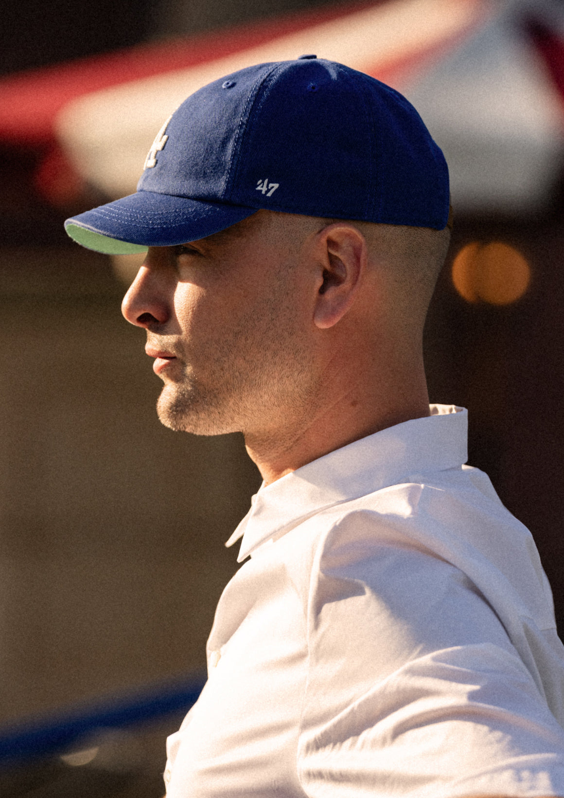 Man wearing a blue cap and white shirt with a blurred background