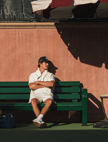 Man sitting on a green bench 