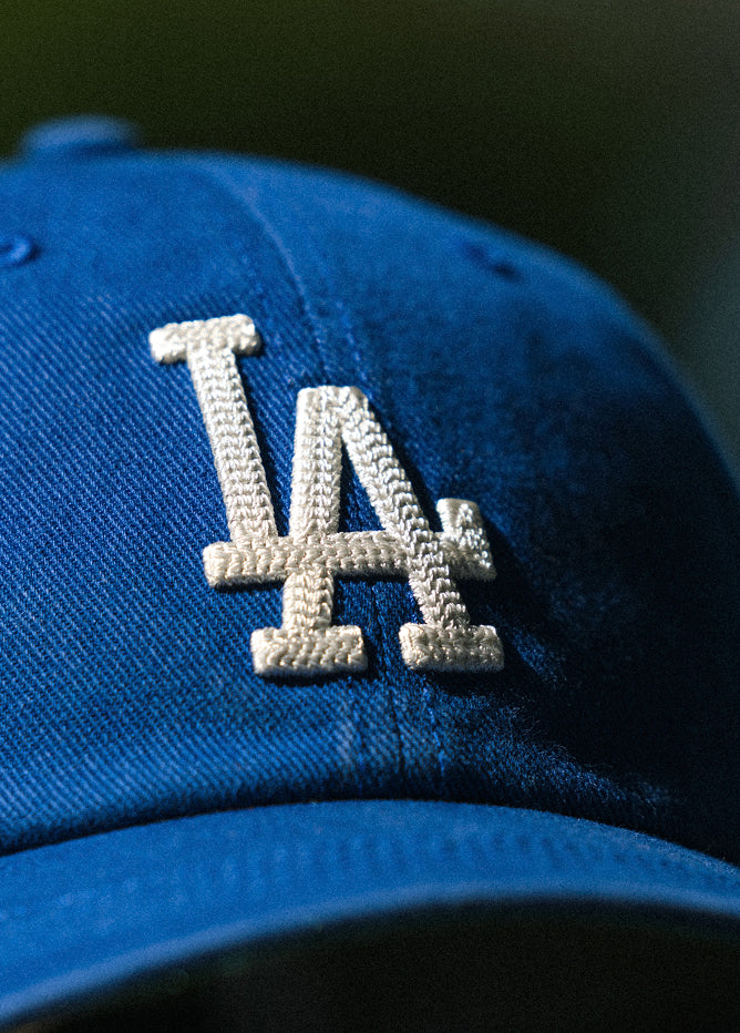 Blue cap with white logo on a dark background