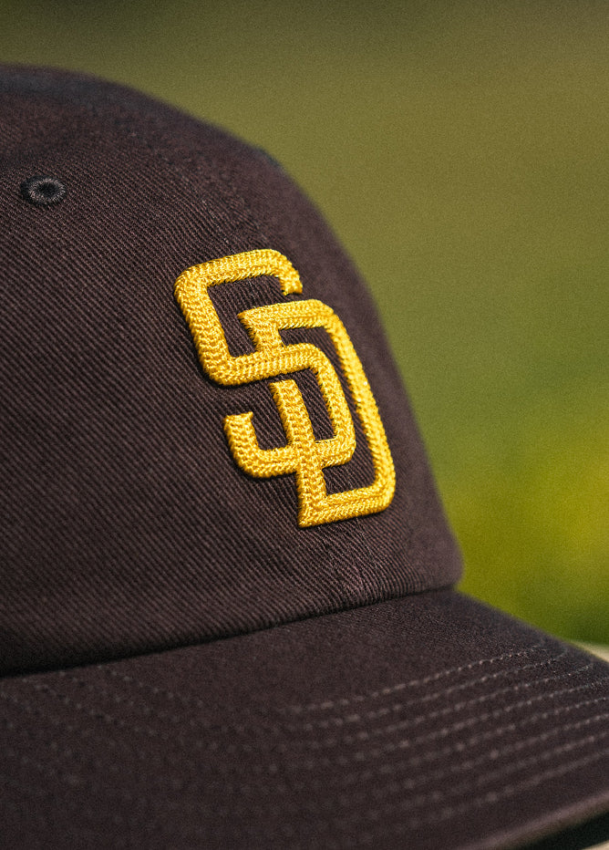 Black cap with yellow logo on a blurred green background