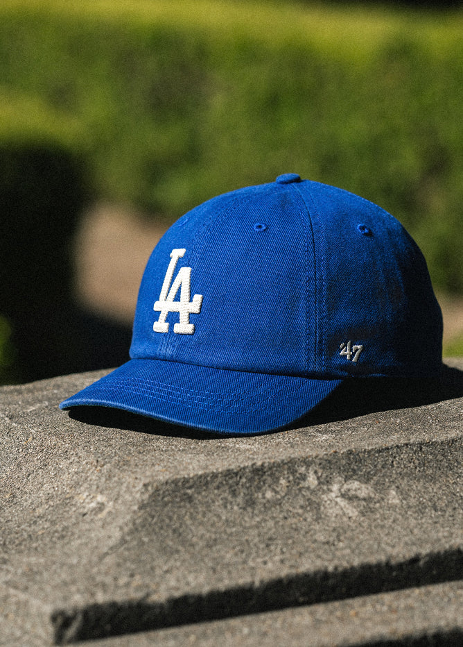 Blue cap with a logo on a stone surface with a blurred green background