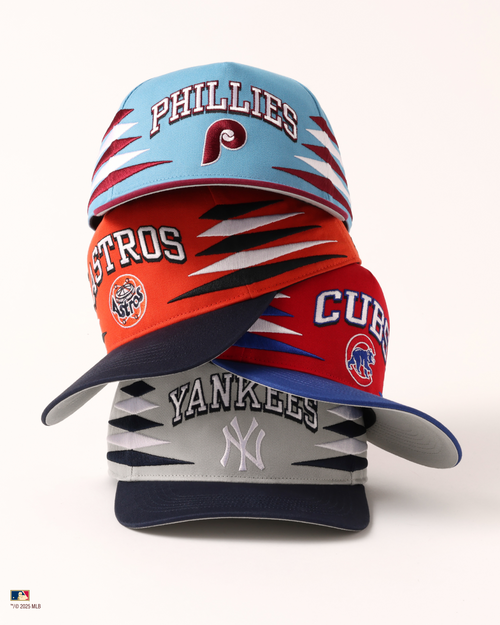 A stack of diamond cut hats- Phillies, Astros, Cubs, Yankees. 