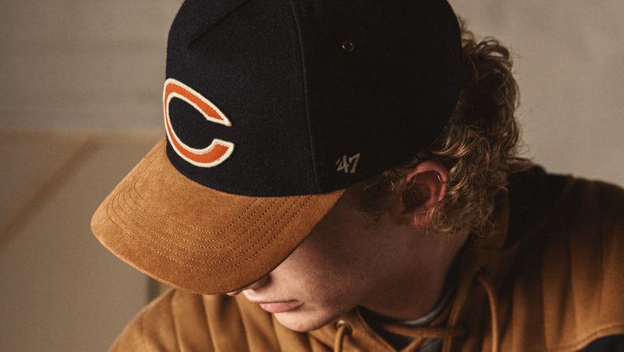 Person wearing a black and brown cap with '47' logo on a neutral background