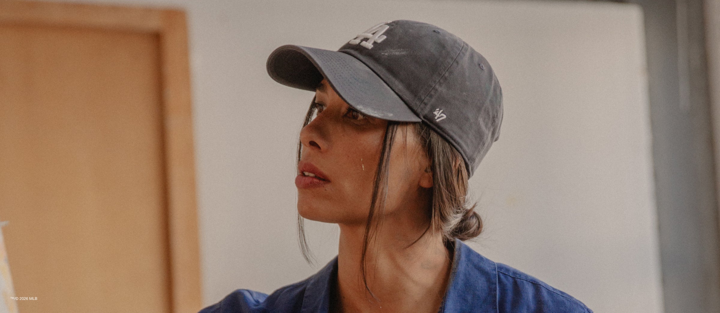 Person wearing a gray cap and blue shirt indoors