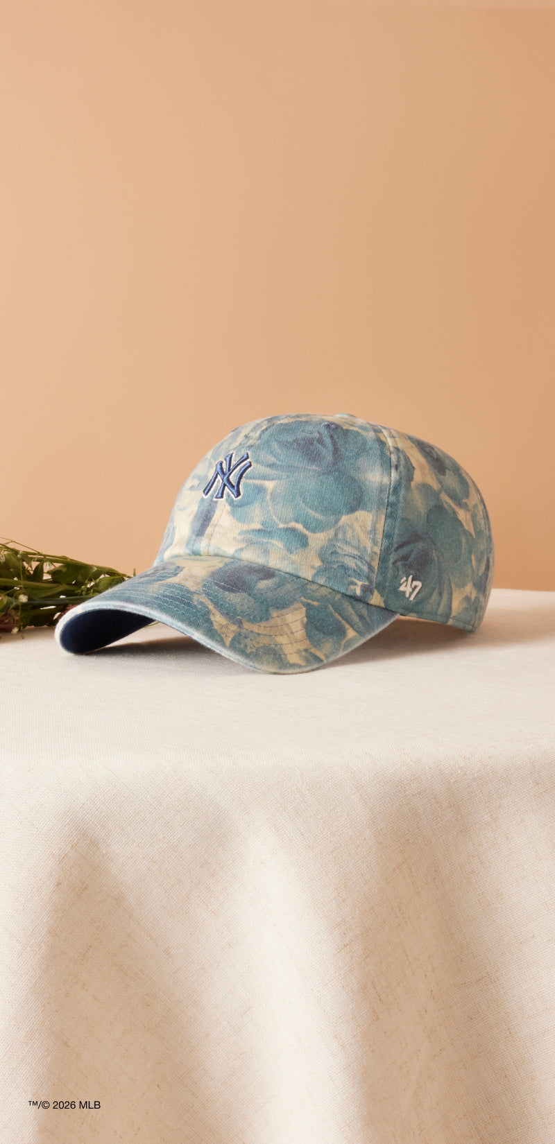 Camouflage-patterned baseball cap on a beige surface with a neutral background